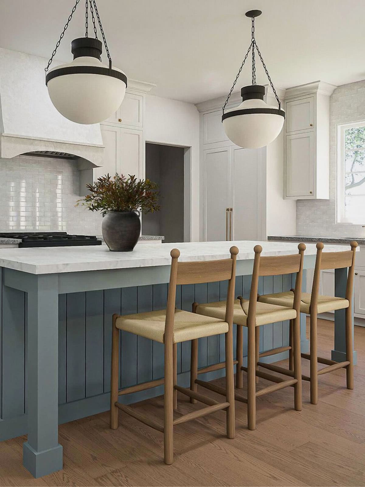 Our proposed materials for kitchen including a French blue island, white perimeter cabinetry, marble countertops, and unlacquered brass hardware.