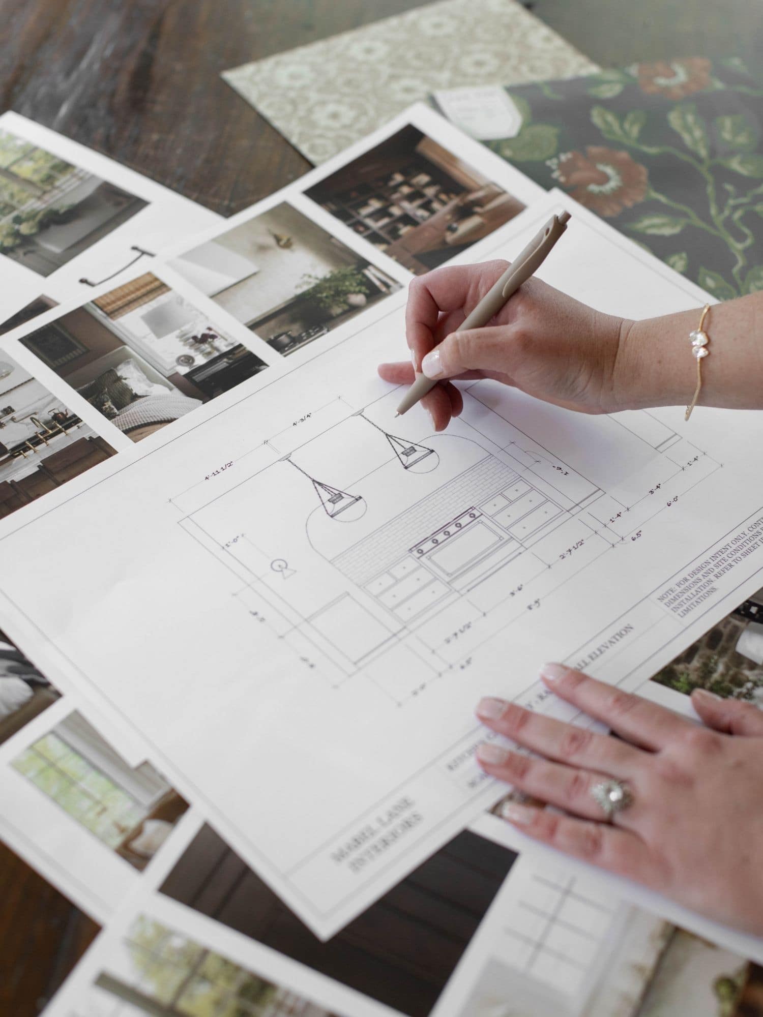 Designer reviewing cabinetry drawings and project specifications during the coordination phase of an interior design project.