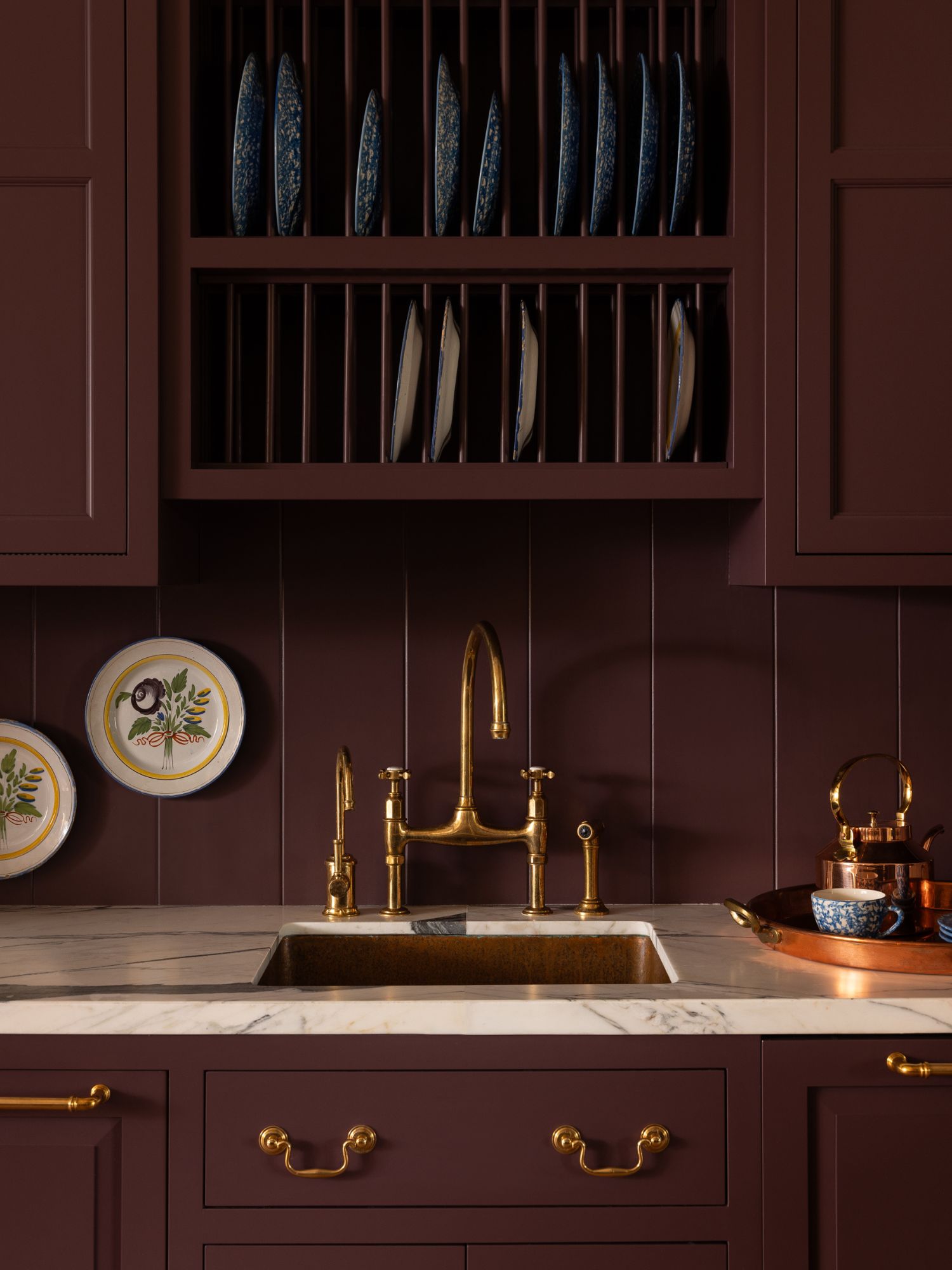 Unlacquered brass faucet and hardware add a living finish to a richly colored kitchen.